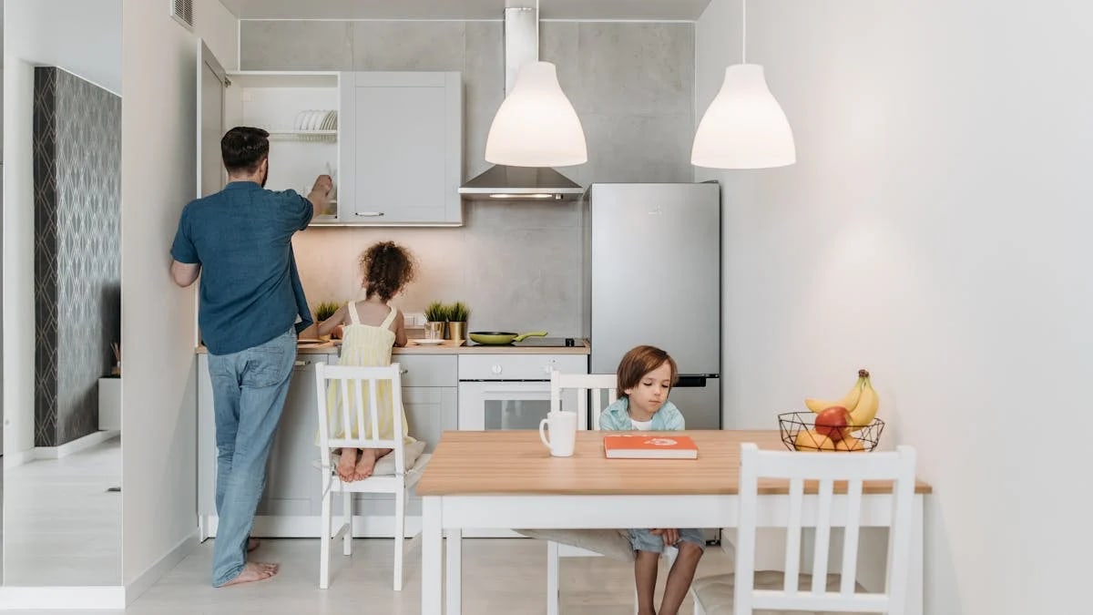 A father and children enjoying quality time in a bright, modern kitchen area.